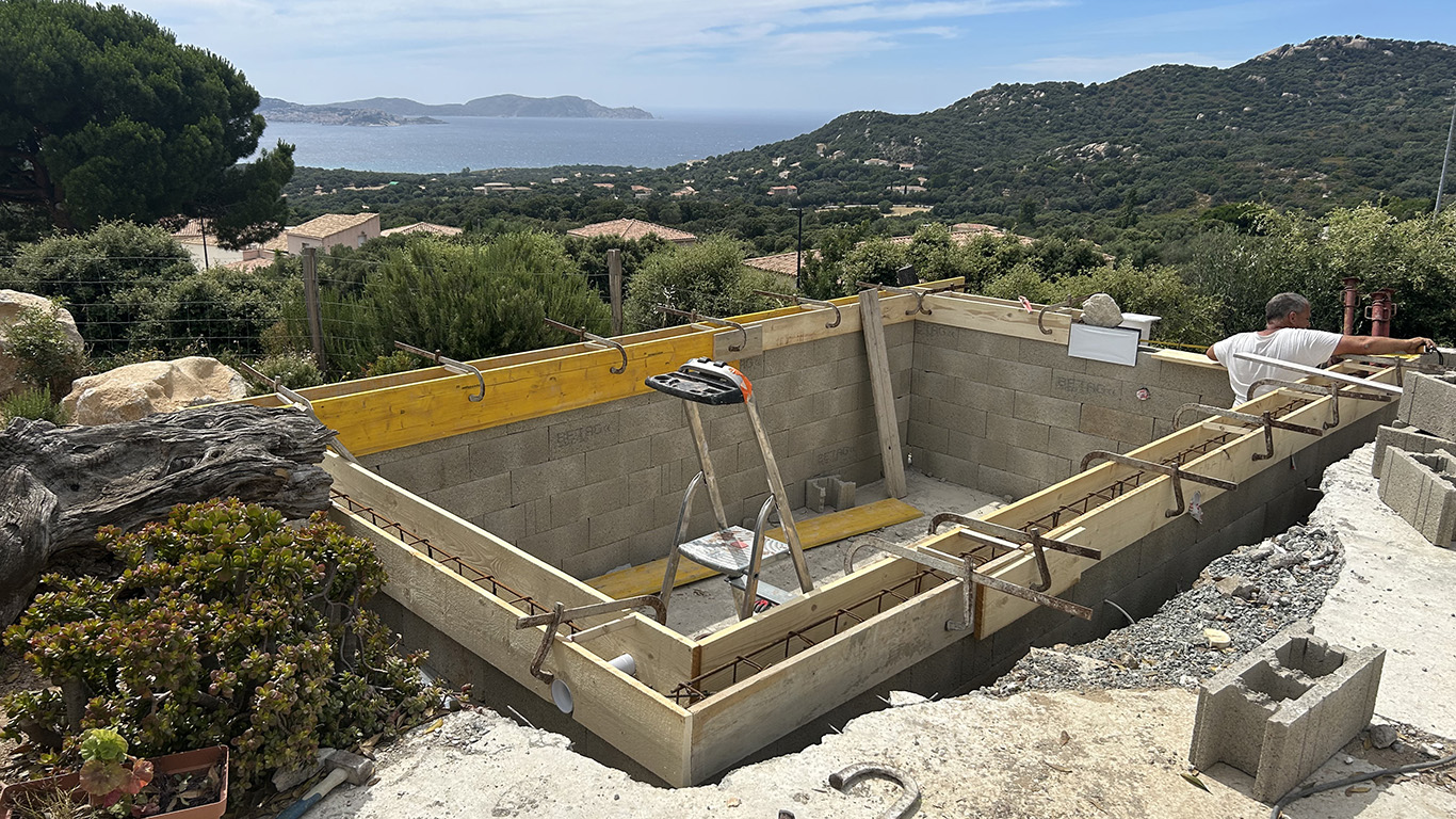 Vue d’ensemble de la piscine maçonnée à Lumio par Munier Construction